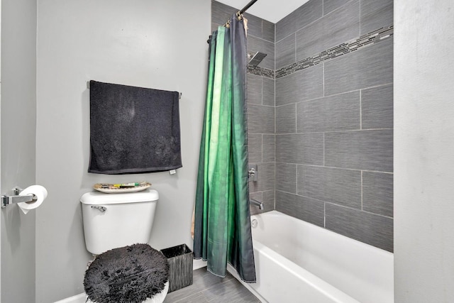 bathroom featuring shower / tub combo and toilet