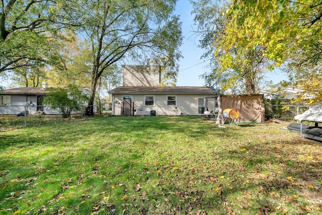 rear view of house featuring a lawn