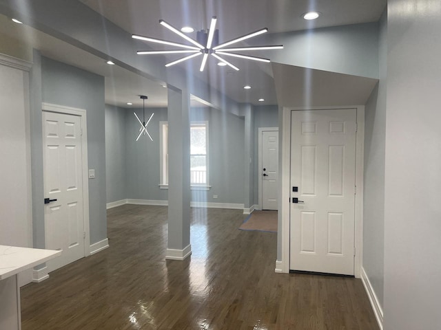 foyer entrance with a notable chandelier and dark hardwood / wood-style floors