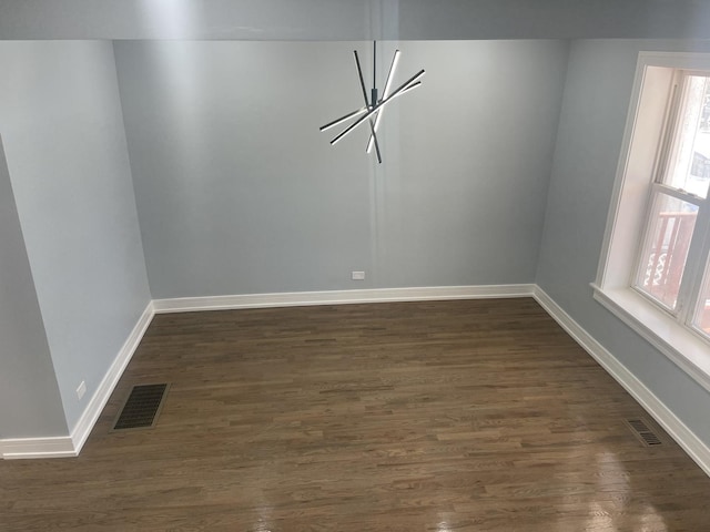 empty room featuring dark wood-type flooring and a wealth of natural light