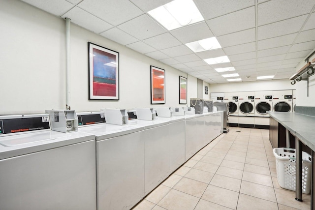 community laundry room featuring light tile patterned floors and washing machine and clothes dryer