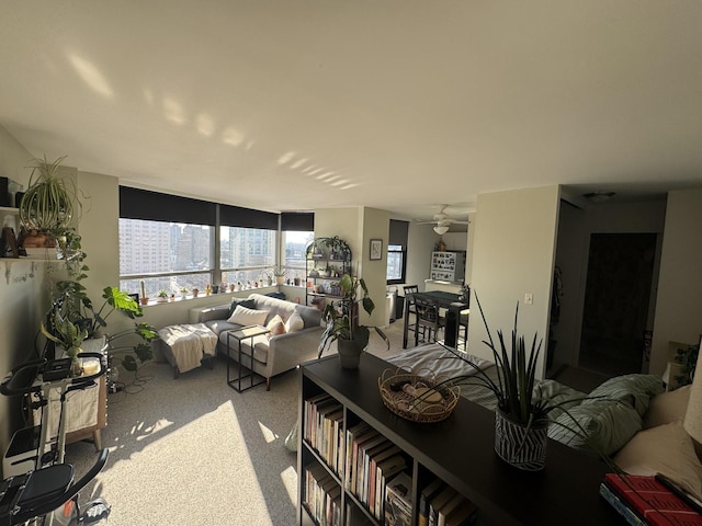 living area with ceiling fan and light colored carpet