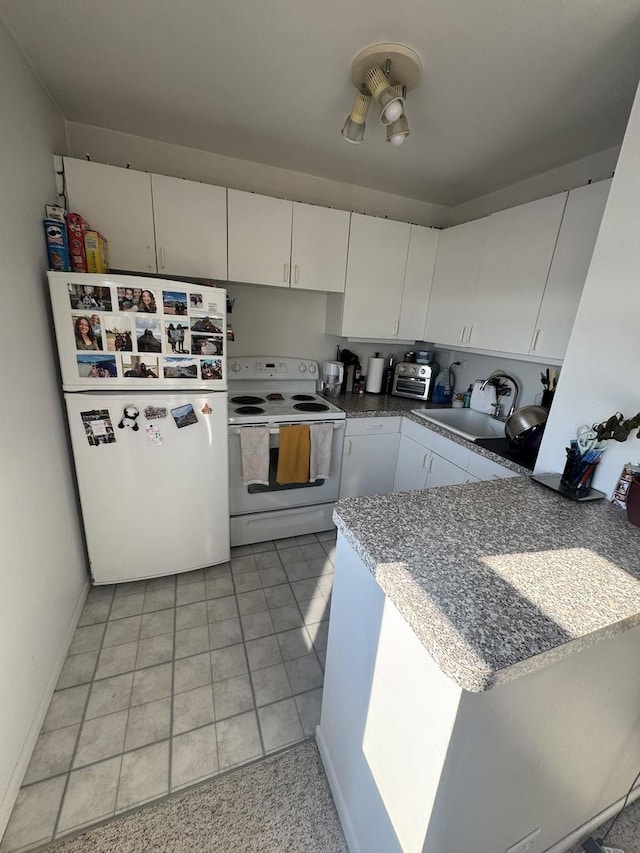 kitchen featuring white electric range oven, white cabinets, a sink, and freestanding refrigerator