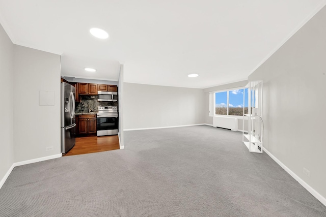 unfurnished living room with ornamental molding and light carpet