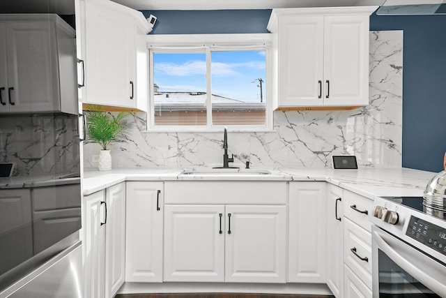 kitchen featuring sink, light stone countertops, and white cabinets