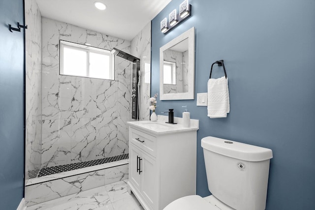 bathroom featuring vanity, tiled shower, and toilet