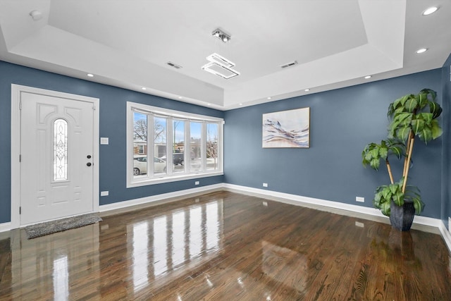 entryway with a tray ceiling and dark hardwood / wood-style flooring