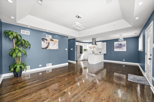 interior space featuring a raised ceiling and wood-type flooring