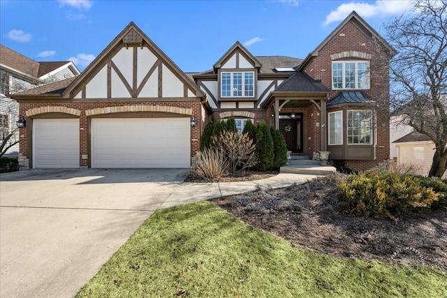 tudor-style house with brick siding, a shingled roof, concrete driveway, stucco siding, and a garage