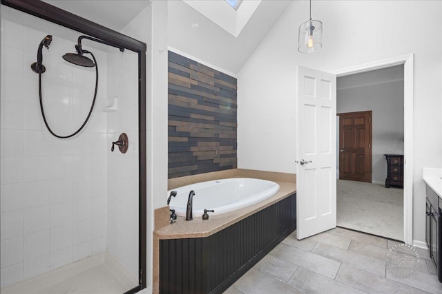 bathroom featuring vaulted ceiling with skylight, a garden tub, and a stall shower