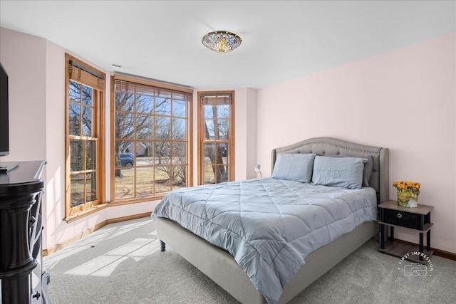 bedroom featuring multiple windows, visible vents, baseboards, and carpet floors