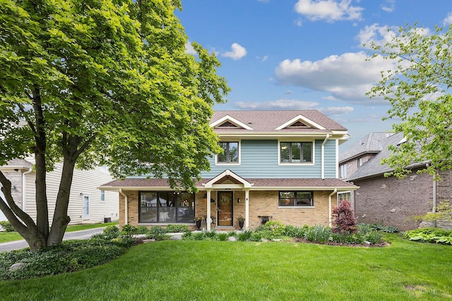 traditional-style home featuring brick siding, roof with shingles, and a front yard