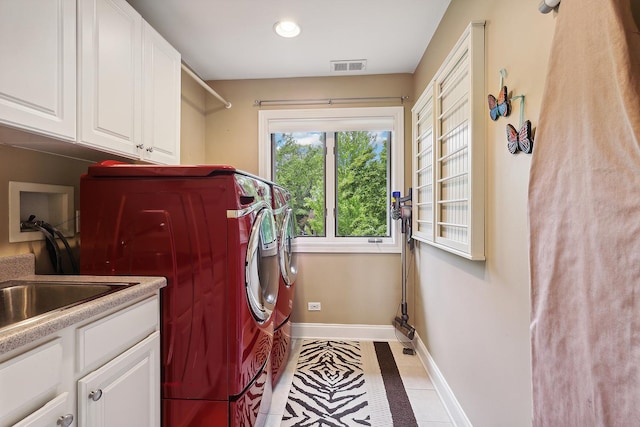 washroom featuring independent washer and dryer, visible vents, cabinet space, and baseboards