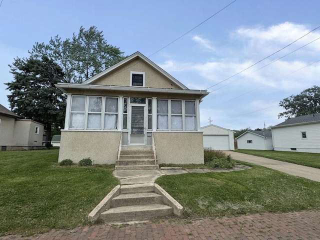 1313 Porter Ave, Lasalle, IL 61301 - bungalow with stucco siding, entry steps, a front lawn, an outdoor structure, and a detached garage