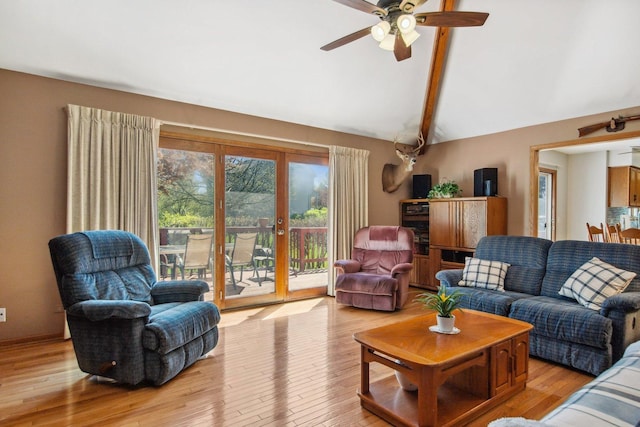 living room featuring lofted ceiling with beams, french doors, wood finished floors, and a ceiling fan