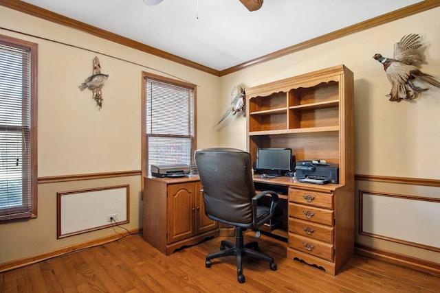 office area featuring plenty of natural light, a wainscoted wall, crown molding, and light wood-style flooring