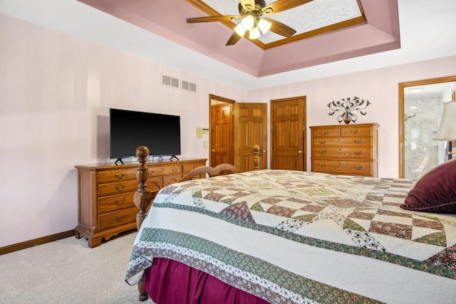 bedroom featuring a raised ceiling, visible vents, light carpet, ceiling fan, and baseboards