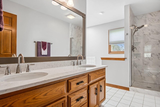 bathroom with double vanity, tile patterned flooring, a marble finish shower, and a sink