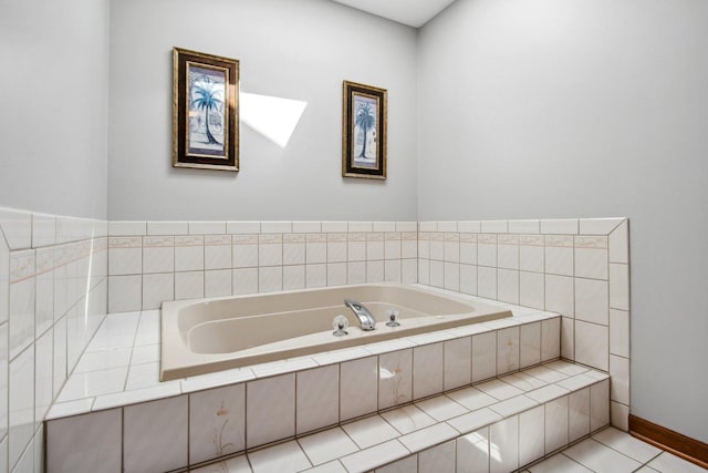 bathroom featuring baseboards, a bath, and tile patterned floors