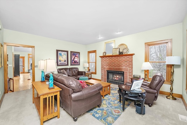 living area featuring a fireplace, baseboards, and carpet flooring
