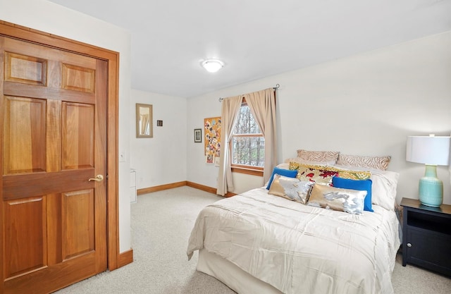 bedroom featuring light colored carpet and baseboards