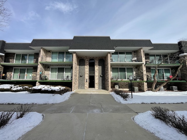 snow covered building featuring central AC unit