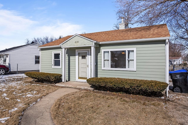 bungalow-style house with roof with shingles