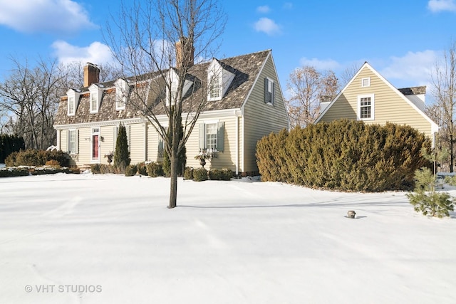 view of snowy exterior with a chimney