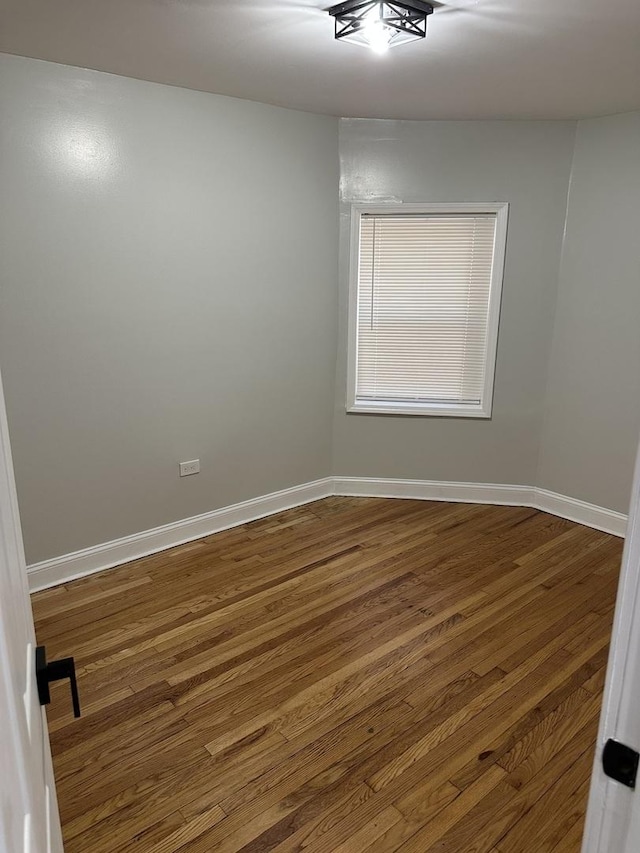 unfurnished room with dark hardwood / wood-style flooring