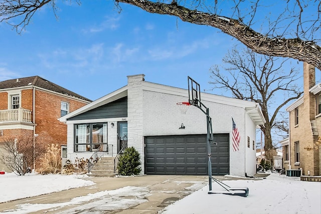 view of front of property featuring an attached garage, central AC unit, concrete driveway, and brick siding