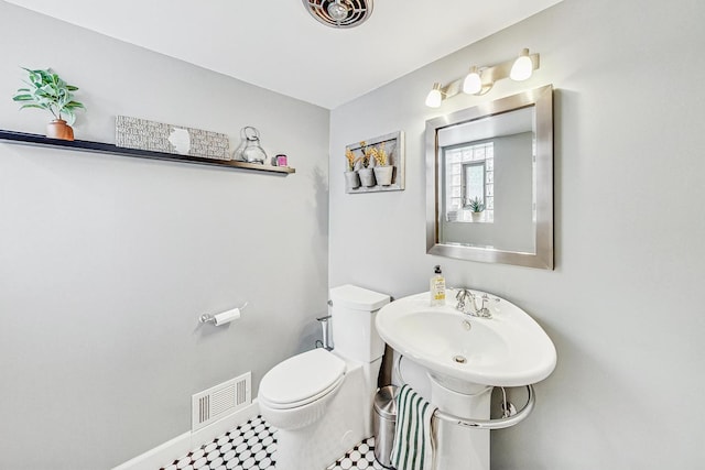 bathroom with baseboards, visible vents, a sink, and toilet