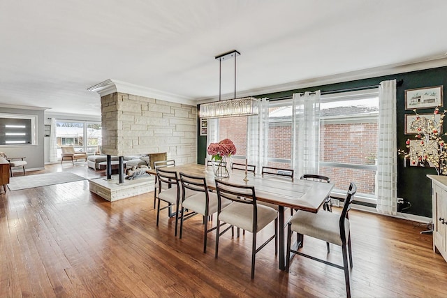 dining area with ornamental molding, wood finished floors, and baseboards