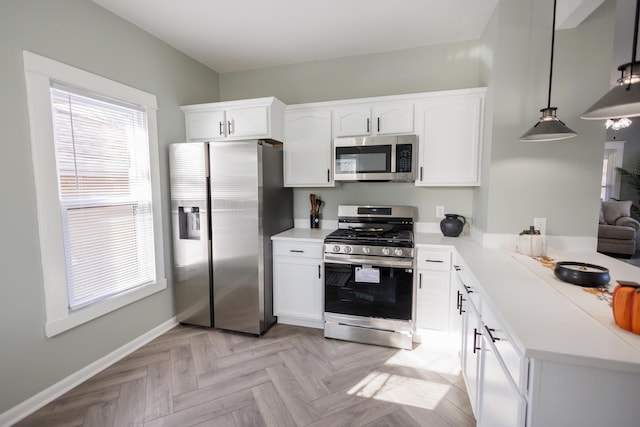 kitchen featuring stainless steel appliances, light parquet flooring, pendant lighting, and white cabinets