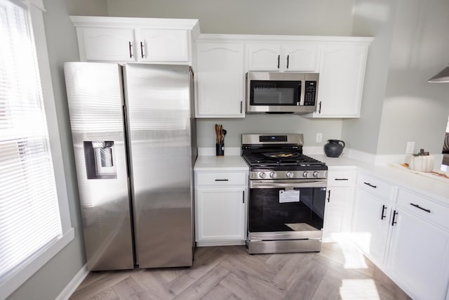 kitchen with white cabinetry, a wealth of natural light, and stainless steel appliances