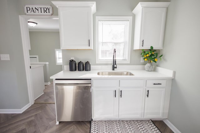 kitchen featuring a healthy amount of sunlight, white cabinets, sink, and dishwasher