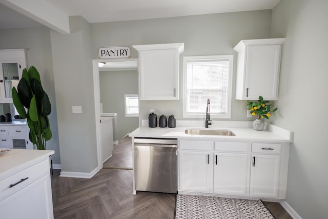 kitchen with sink, stainless steel dishwasher, white cabinets, and parquet floors