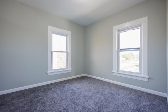 spare room with dark colored carpet