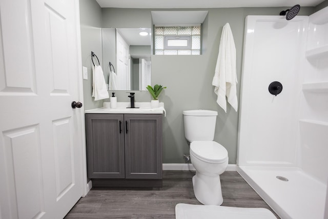 bathroom featuring hardwood / wood-style flooring, vanity, toilet, and walk in shower