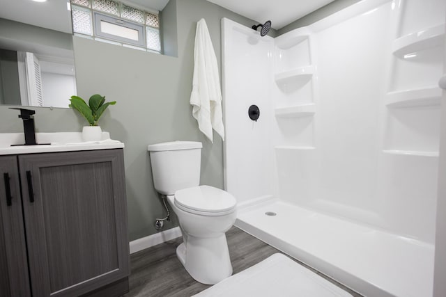 bathroom with vanity, hardwood / wood-style flooring, toilet, and walk in shower