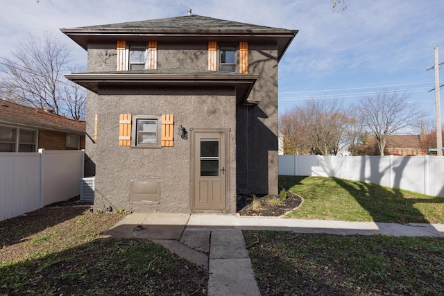 back of property with central AC and a yard