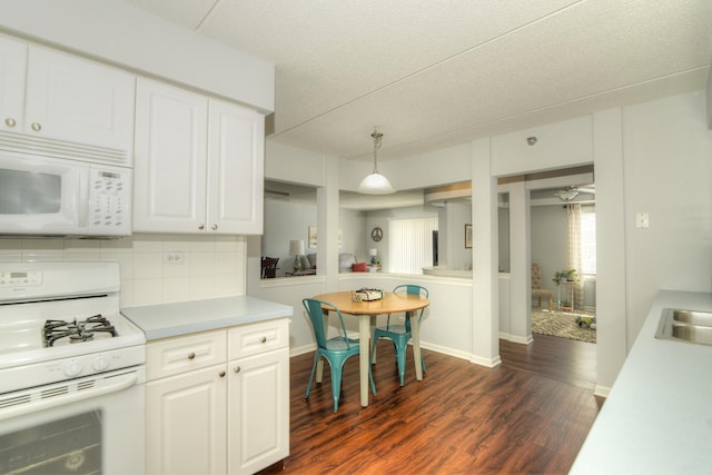 kitchen with white cabinets, dark hardwood / wood-style flooring, decorative backsplash, hanging light fixtures, and white appliances