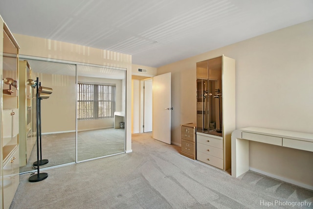 unfurnished bedroom with carpet floors, visible vents, and a closet