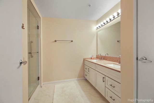 bathroom with baseboards, double vanity, a sink, and a shower stall