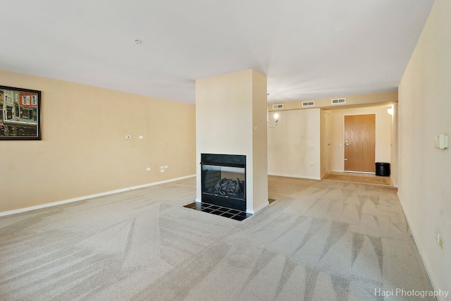 unfurnished living room featuring carpet floors, baseboards, visible vents, and a multi sided fireplace