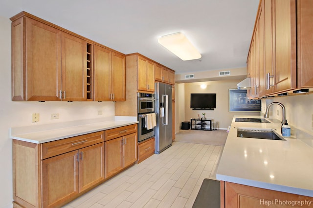 kitchen featuring open shelves, light countertops, visible vents, appliances with stainless steel finishes, and a sink