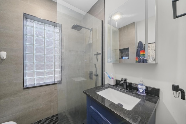 bathroom featuring a tile shower and vanity