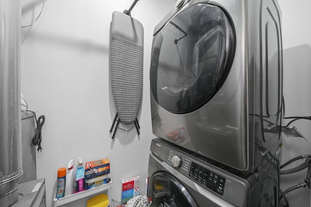 clothes washing area with stacked washing maching and dryer