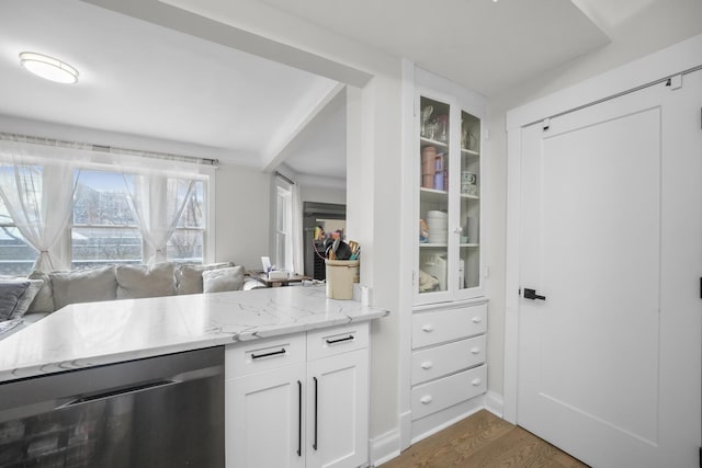 kitchen with dark hardwood / wood-style flooring, dishwasher, light stone counters, and white cabinets