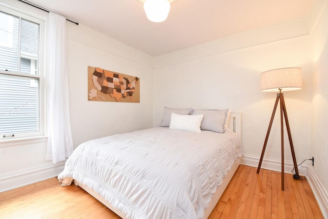 bedroom with hardwood / wood-style flooring and baseboards