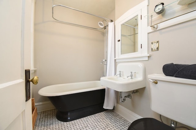 full bath featuring toilet and baseboards